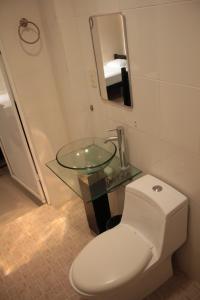 a bathroom with a toilet and a glass sink at Hotel Calle8 in Tuxtla Gutiérrez