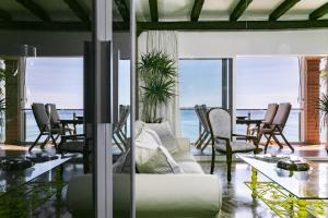 多列毛利诺斯Apartamento Playa Centro Vistas Mar的客厅里有一张沙发、一张桌子和几把椅子