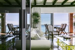 - un salon avec un canapé et une table avec des chaises dans l'établissement Apartamento Playa Centro Vistas Mar, à Torremolinos