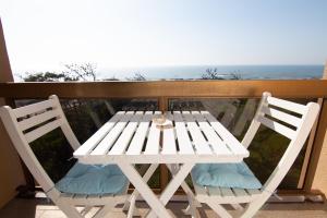 a white table and chairs on a balcony with the ocean at Casa da Praia in Viana do Castelo