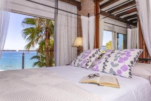 多列毛利诺斯Apartamento Playa Centro Vistas Mar的一间卧室配有一张带书本的床和窗户 更多37张照片