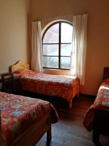 a room with two beds and a window at Casa Treveris - Non profit Hostel in Sucre