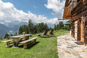a picnic table and chairs in the grass next to a building at Chalet Berghaus Bartholomäberg in Bartholomäberg