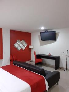 Dormitorio con cama, escritorio y TV en Hotel CEO en Morelia