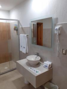 y baño con lavabo, espejo y ducha. en Hotel CEO en Morelia