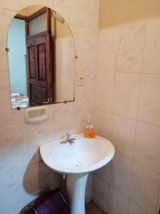 a bathroom with a white sink and a mirror at Casa Treveris - Non profit Hostel in Sucre