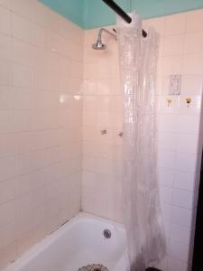 a bathroom with a tub with a shower curtain at Casa Treveris - Non profit Hostel in Sucre +49 photos