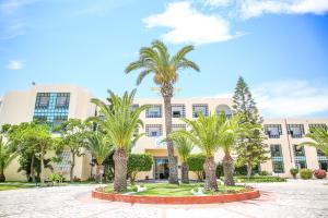 a building with palm trees in front of it at Palm Beach Club Marmara Skanes in Monastir