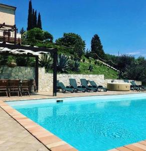 a swimming pool with chairs next to a house at Villa Azzurra in Porto SantʼElpidio