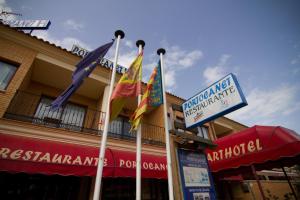 un grupo de banderas en postes frente a un edificio en Portocanet Complejo Turístico, en Canet de Berenguer