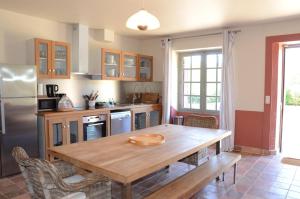 a kitchen with a wooden table and a refrigerator at Gite Familial Chateau La Roche Racan in Saint-Paterne-Racan