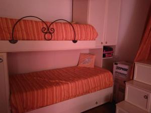 1 dormitorio con 2 literas y edredón naranja en Ca Rosella en Sorso