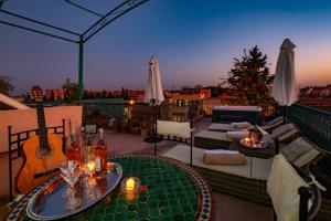 a rooftop patio with a table and a guitar at Villa Soraya Hammam & Jacuzzi in Marrakesh