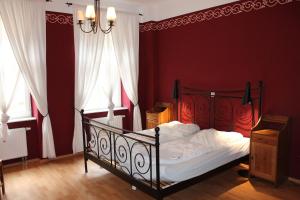 a bedroom with a bed with red walls and a chandelier at Hostel Louise 20 in Dresden