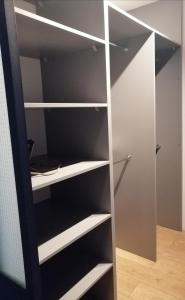 a black and white closet with white shelves at Apartament w Centrum in Szczecin