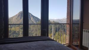 a bedroom with a large window with a view of mountains at Hotel Granja Paraíso, Oasis Rural & Bienestar in Cangas de Onís