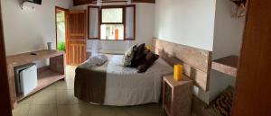 a bedroom with a bed with a dog laying on it at Estalagem Meu Sonho in Penedo