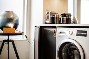 a kitchen with a washing machine and a table at Central city apartment in Launceston