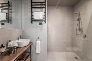 a white bathroom with a sink and a shower at Central city apartment in Launceston +22 photos