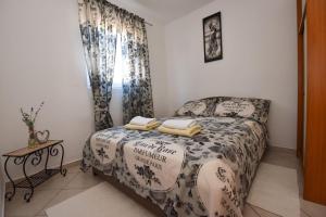 Dormitorio pequeño con cama y mesa en Apartment Kety - cosy with balcony, en Novalja