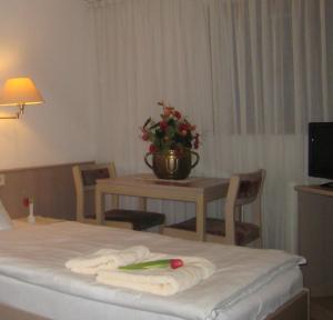 a hotel room with a table with towels on a bed at Zum Flößer in Neckartenzlingen
