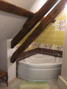a bath tub in a bathroom with wooden beams at Les Maitres Sonneurs in Huriel