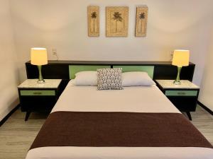 um quarto com uma cama com 2 mesas de cabeceira e 2 candeeiros em Suites Havre em Cidade do México
