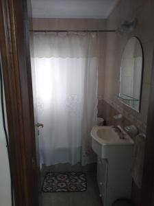 y baño con cortina de ducha y lavamanos. en Depto semicentrico. en Tandil