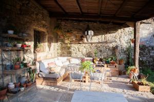 a patio with a couch and a table and chairs at Casa Rural Priorato San Martín in Amés
