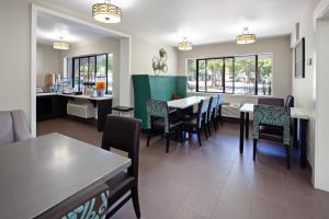 uma sala de jantar com mesas, cadeiras e janelas em Hotel Vue em Mountain View