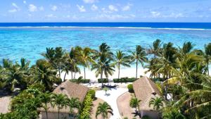 an aerial view of a resort with palm trees and the ocean at Motu Beachfront Art Villas in Rarotonga