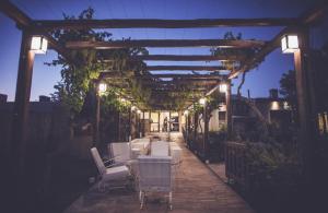 een patio met stoelen en een pergola met verlichting bij La Finca Multiespacio in San Rafael