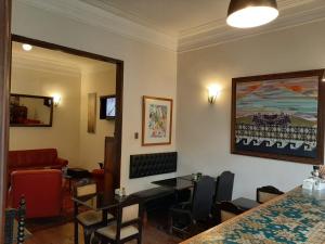 Santa Rosa Apartotel- Centro Histórico في ليما: غرفة انتظار مع طاولات وكراسي ودهان على الحائط