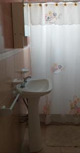 a bathroom with a sink and a shower curtain at Cabaña Don Oscar in Federación