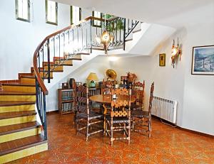 uma sala de jantar com uma mesa e uma escada em Casa Kirbo em Altea