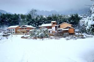 a house is covered in snow at Dayong Antique Feature Resort in Zhangjiajie