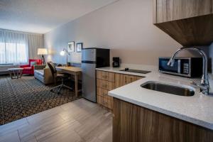 a kitchen with a sink and a living room at Days Inn & Suites by Wyndham Rochester Hills MI in Rochester Hills