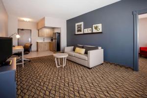 a living room with a couch and a kitchen at Days Inn & Suites by Wyndham Rochester Hills MI in Rochester Hills