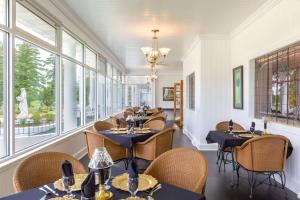 un comedor con mesas, sillas y ventanas en Four Seasons Island Resort en Pembine