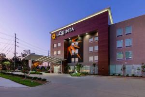 a building with a sign on the side of it at La Quinta Inn & Suites by Wyndham Lafayette Oil Center in Lafayette