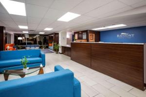 a lobby with blue chairs and a reception desk at Baymont by Wyndham Spokane in Spokane