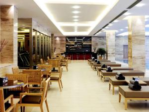 a restaurant with wooden chairs and tables and a cafeteria at Pullman Linyi Lushang in Linyi