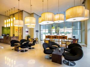 a restaurant with black chairs and tables and chandeliers at ibis Deira Creekside Dubai in Dubai