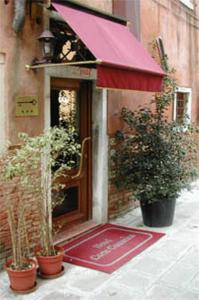 un accès à un bâtiment avec des plantes en pot sur le trottoir dans l'établissement Hotel Corte Contarina, à Venise