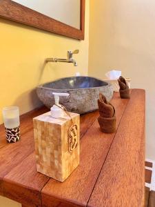 a bathroom with a stone sink on a wooden counter at Uluwatu Sunrise in Uluwatu +30 photos