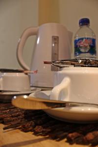 una mesa con platos y tazas y un hervidor de agua. en Exotic Komodo Hotel, en Labuan Bajo