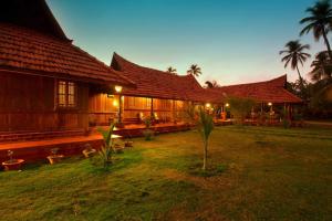 une maison avec une cour d'herbe devant elle dans l'établissement Kondai Lip Backwater Heritage Resort, à Cochin