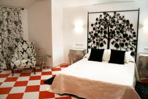 1 dormitorio con cama blanca y suelo a cuadros en Hostal Mesón Castilla, en Sigüenza