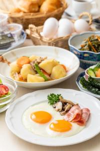 uma mesa coberta com pratos de ovos e alimentos em Orange Inn Sendaihigashi em Sendai