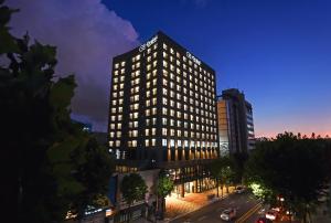 ソウルにあるOrakai Daehakro Hotelの看板が上がる高層ビル